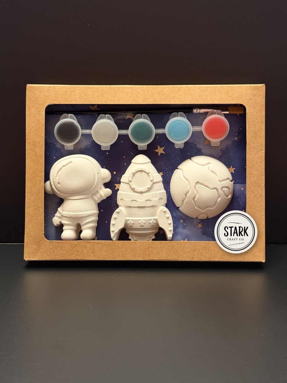 Unpainted space kit: astronaut, rocket and planet in a kraft window box with paints